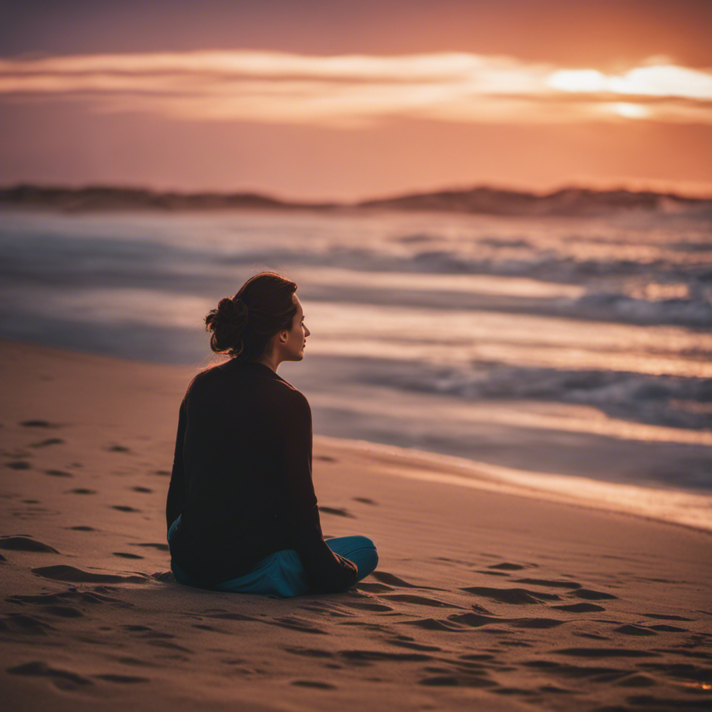An image depicting a serene beach scene, showcasing a person sitting cross-legged on the sand, eyes closed, hands gently resting on their knees, surrounded by softly crashing waves and a vibrant sunset sky